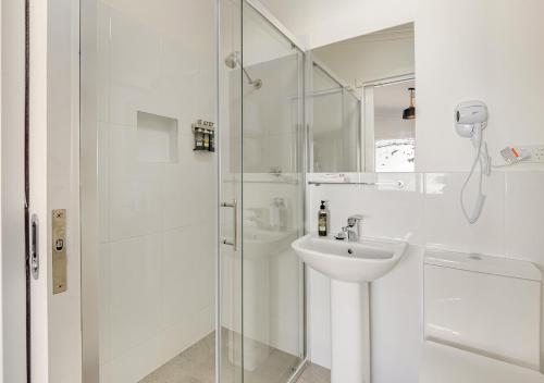 佩里舍峡谷谷特加旅馆的白色的浴室设有水槽和淋浴。