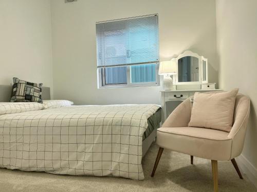 悉尼The South bay's home-Small RoomB的一间卧室配有一张床、一把椅子和镜子