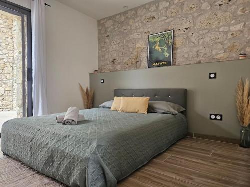 Villa & Spa Luxuria的一间卧室设有一张床和石墙