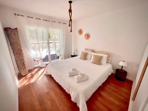 赞布热拉-杜马尔Zambujeira Terrace的一间卧室配有一张床,上面放着两个托盘
