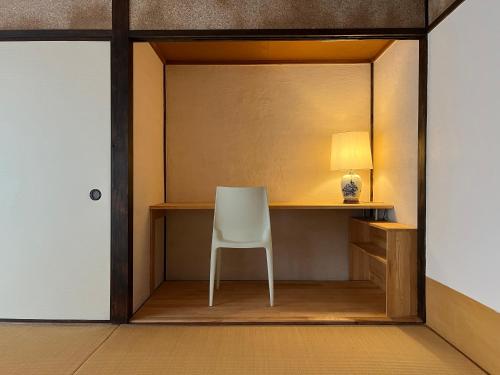 长崎AKUNOURA HUIS的一间带椅子和一张台灯的桌子的房间