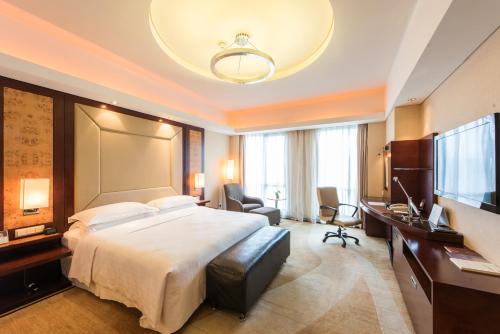 温州温州喜来登酒店的酒店客房设有一张大床和一张书桌。