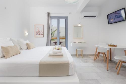 纳克索乔拉萨斯一室公寓的白色的客房设有一张白色的大床和一张桌子。