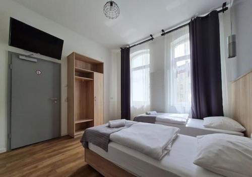 汉诺威Aparthotel Lenau的一间卧室配有两张床和一台平面电视