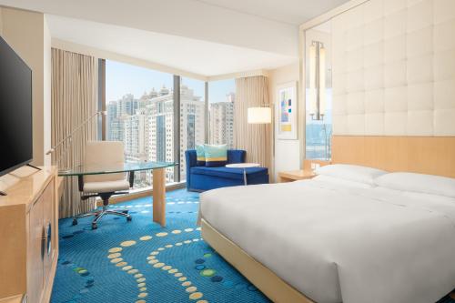 上海上海豫园万丽酒店的酒店客房配有一张床、一张书桌和一台电视。