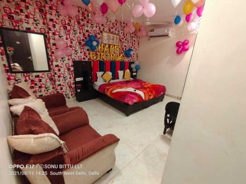新德里OYO Hotel Shivam In的一间卧室配有一张床、一张沙发和气球