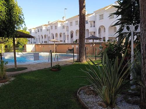 奇克拉纳－德拉弗龙特拉Apartamento La Caracola的一座带游泳池的度假村,位于一座建筑前