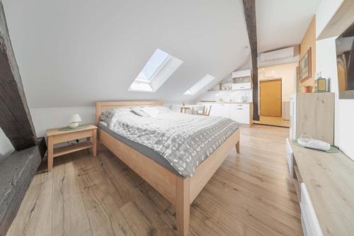 科希策GUDU apartments的一间卧室配有一张床,铺有木地板