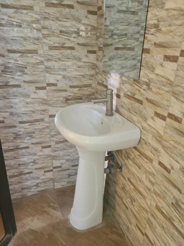 多多马Peacefully Resort的浴室设有白色水槽和镜子