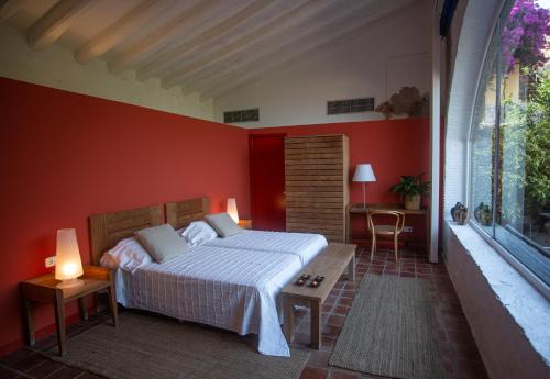 EspollaHotel Canaleta Heras的卧室配有红色墙壁内的一张床