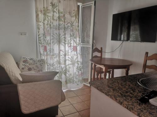 科尼尔-德拉弗龙特拉Sol y playa的厨房以及带沙发和桌子的客厅。