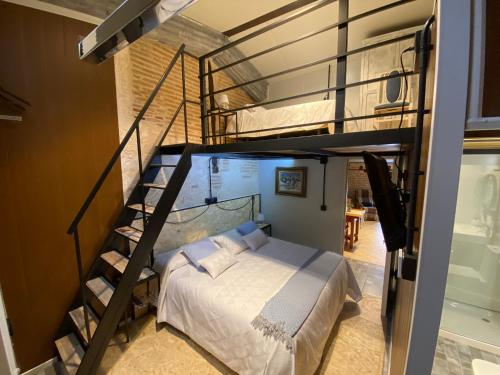 Nava del ReyCASA RUINA的一间卧室设有双层床和螺旋楼梯。