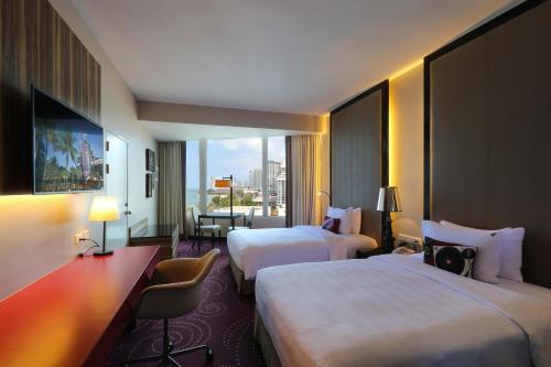 芭堤雅市中心Hard Rock Hotel Pattaya的酒店客房设有两张床和大窗户。
