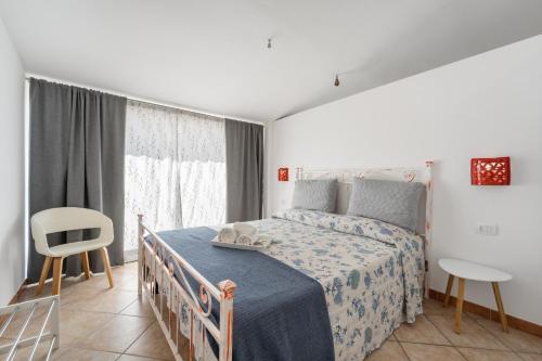 ElmasLe tenute del mandarino的卧室配有床、椅子和窗户。