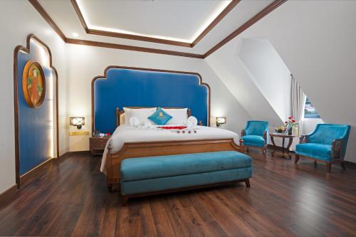 下龙湾Grand Fleuve Boutique的一间卧室配有蓝色的床和两张蓝色椅子