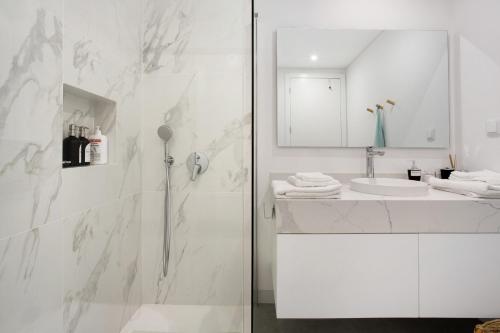 卡马拉-德洛布什Casa Castanheta的带淋浴和盥洗盆的白色浴室