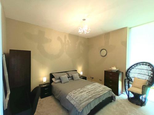 沃特福德Beautiful 2-Bed Apartment near Waterford City的一间卧室配有一张床和一把椅子