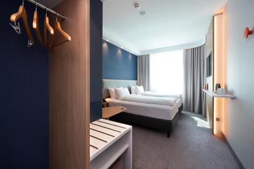 巴塞尔Holiday Inn Express & Suites - Basel - Allschwil, an IHG Hotel的酒店客房设有两张床和窗户。