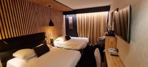 拉罗谢尔丽布立思酒店的酒店客房设有两张床和电视。