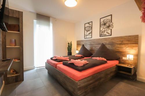 维林根Appartementhaus kleines Glück &MeineCardPLUS的一间卧室配有一张大床和木制床头板