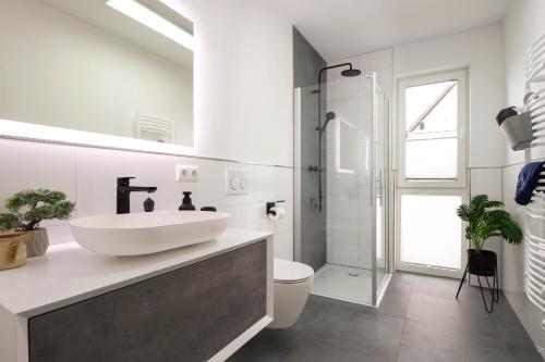 维林根Appartementhaus kleines Glück &MeineCardPLUS的白色的浴室设有水槽和淋浴。