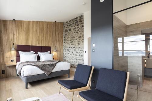 伊苏瓦尔Hôtel & Restaurant Origines par Adrien Descouls - Teritoria的一间卧室配有一张床和两把椅子