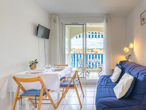 朋泰雷克Apartment Parc de Pontaillac-21 by Interhome的客厅配有桌子和蓝色沙发