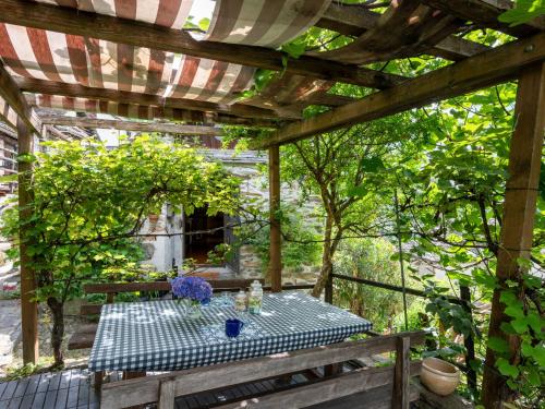BognancoChalet Il Gianlupo by Interhome的花园凉棚下的野餐桌