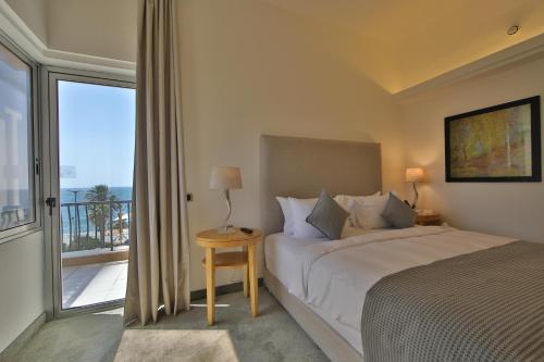 贝鲁特Riviera Hotel and Beach Lounge, Beirut的一间卧室设有一张床和一个大窗户