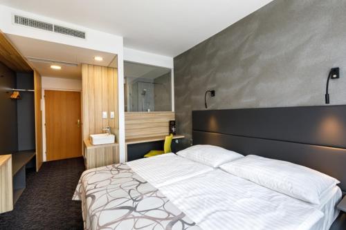俄斯特拉发协和俱乐部酒店的一间带白色大床的卧室和一间浴室