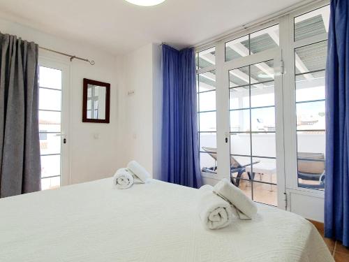 阿德耶卡萨皮斯西斯旅馆的卧室配有带毛巾的大型白色床