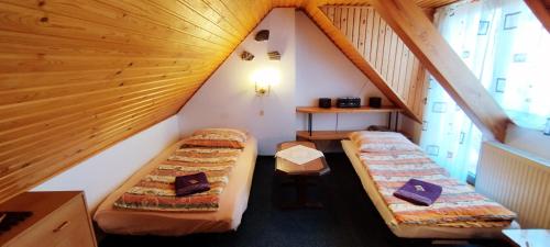 拉贝河畔罗乌德尼采Chata Lucie的阁楼间设有两张床和楼梯。