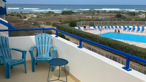 拉卡诺奥肯BELLE VUE OCEAN, 2 CHAMBRES, terrasse 30m2, parking privatif et piscine en été的一个带两把椅子的阳台和一个游泳池