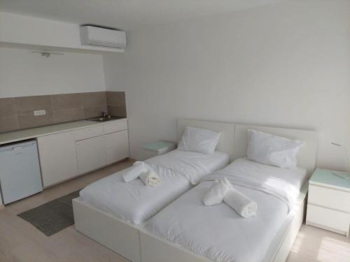 蒂米什瓦拉Casa Maria City Apartments的白色客房 - 带2张床和毛巾