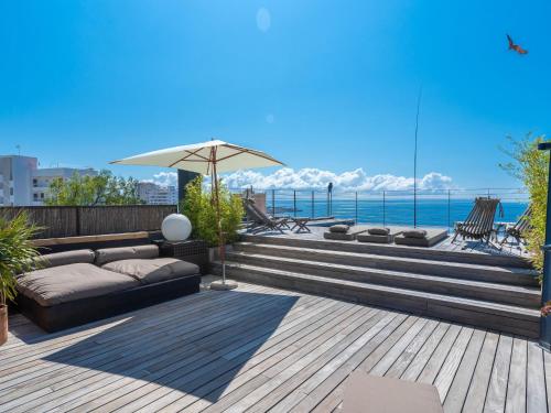 马略卡岛帕尔马Villa Vistamar by Interhome的一个带沙发和遮阳伞的庭院和大海