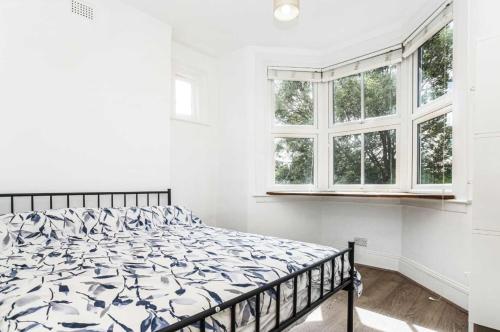 伦敦Bright and Stylish 2 Bedroom First Floor Flat的白色卧室内的一张床位,设有窗户