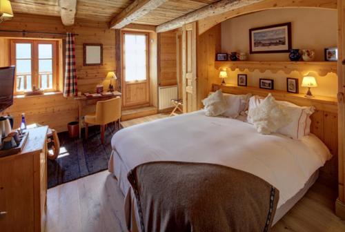 欧特吕斯La Ferme du Chozal, Chalet de tradition的卧室配有一张白色大床