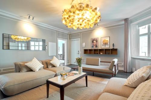 哥本哈根Stylish 4 Bedroom flat in CPH City的客厅配有两张沙发和一个吊灯。