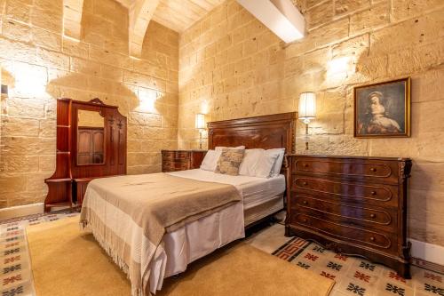 瓦莱塔Stunning Valletta Palazzino的一间卧室配有一张床和一个梳妆台