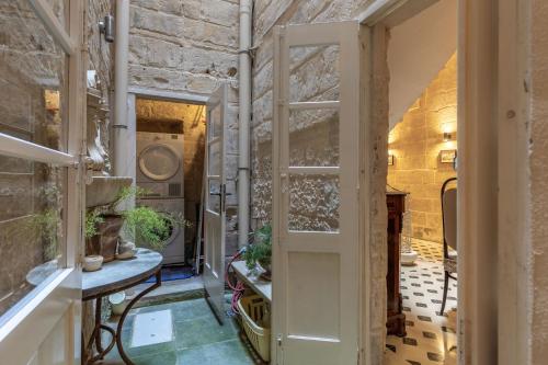 瓦莱塔Stunning Valletta Palazzino的一间设有开放式门的房间和一张植物桌子