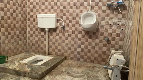 德奥加尔Parmarth Lok的一间带卫生间、小便器和盥洗盆的浴室