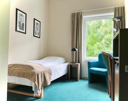 SandRyfylke Fjordhotel的卧室配有床、椅子和窗户。