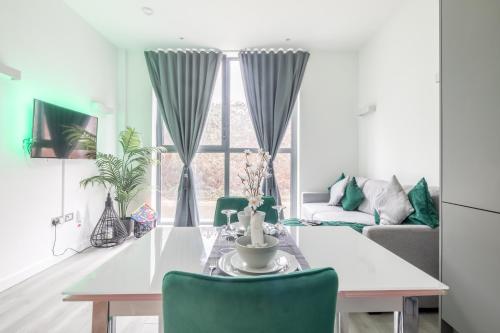 米尔顿凯恩斯Elegant apartment的客厅配有白色桌子和绿色椅子