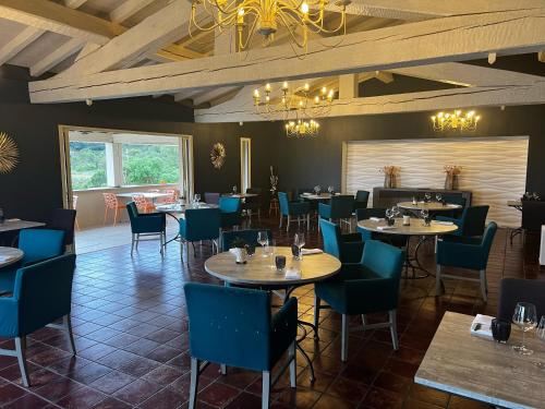 Aragon贝日里餐厅酒店的一间配备有桌子和蓝色椅子的用餐室