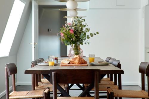 哥本哈根LUXURY Penthouse · Private Balcony · Heart of Copenhagen的花瓶带餐桌的餐桌