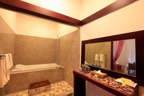 库塔薰衣草别墅假日公园及Spa的带浴缸、水槽和镜子的浴室