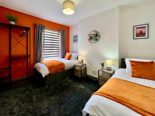 诺丁汉Birkin House - Great for Contractors or Family Holidays的橙色墙壁客房的两张床