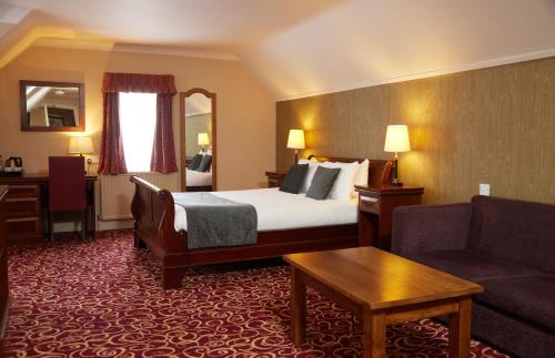 马克菲尔德Fieldhead Hotel by Greene King Inns的酒店客房,配有床和沙发