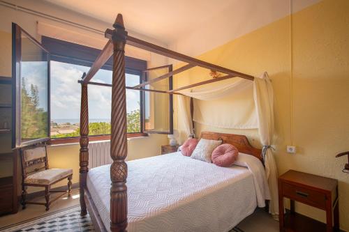 阿尔塔夫拉Habitaciones Villa Marcia Solo Adulto的一间卧室设有天蓬床和窗户。