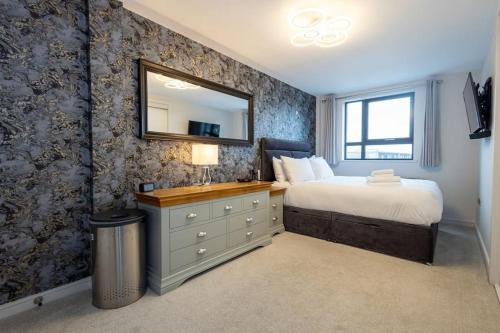 曼彻斯特The Didsbury的一间卧室配有一张带梳妆台和镜子的床